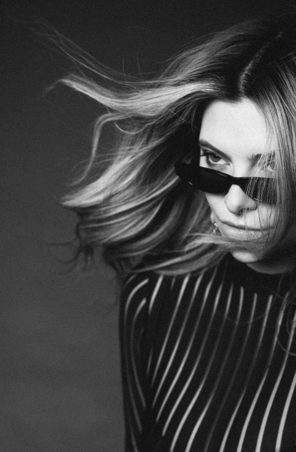 Windblown hair and narrow sunglasses in black and white