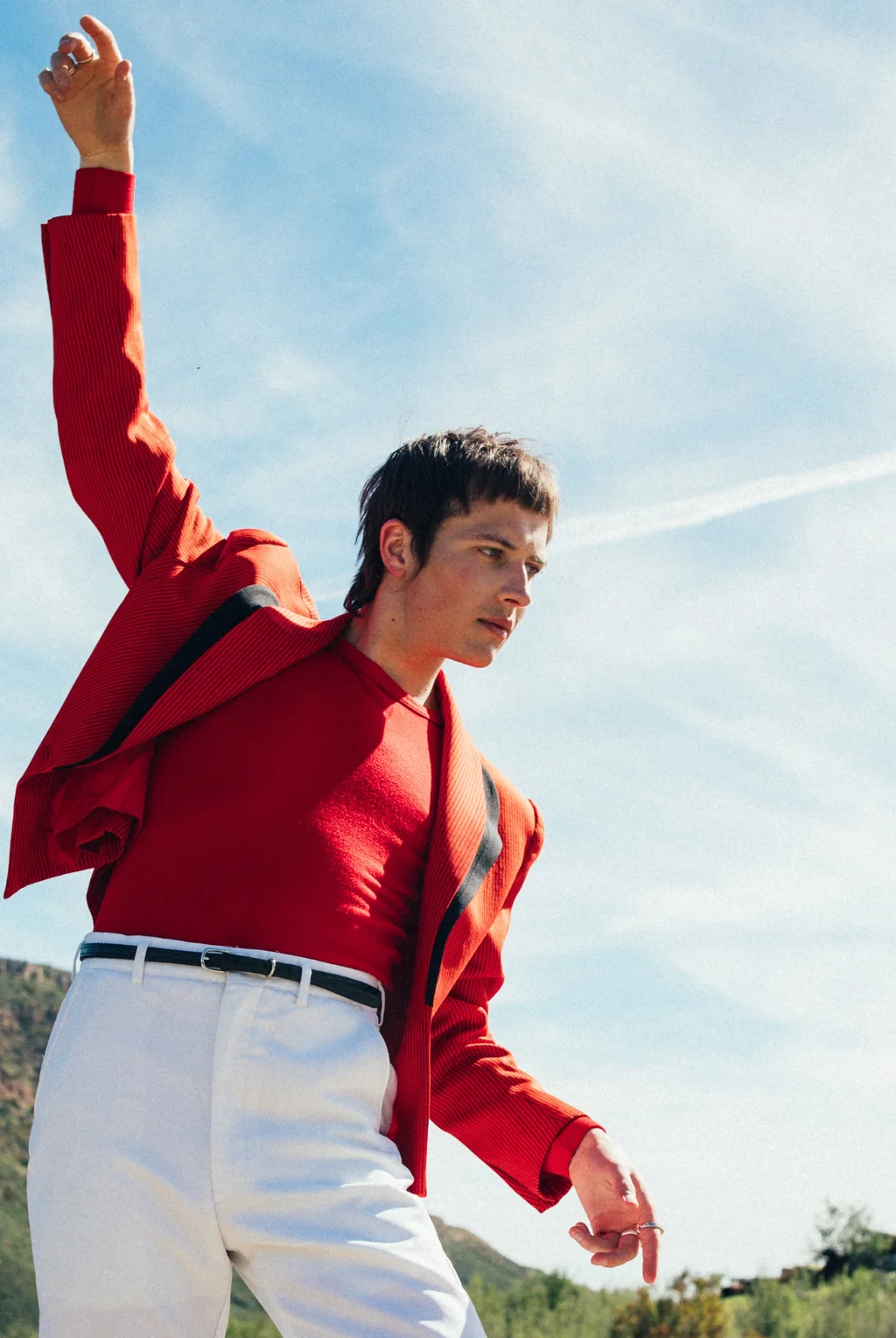 A red jacket and white trousers beneath a bright blue sky