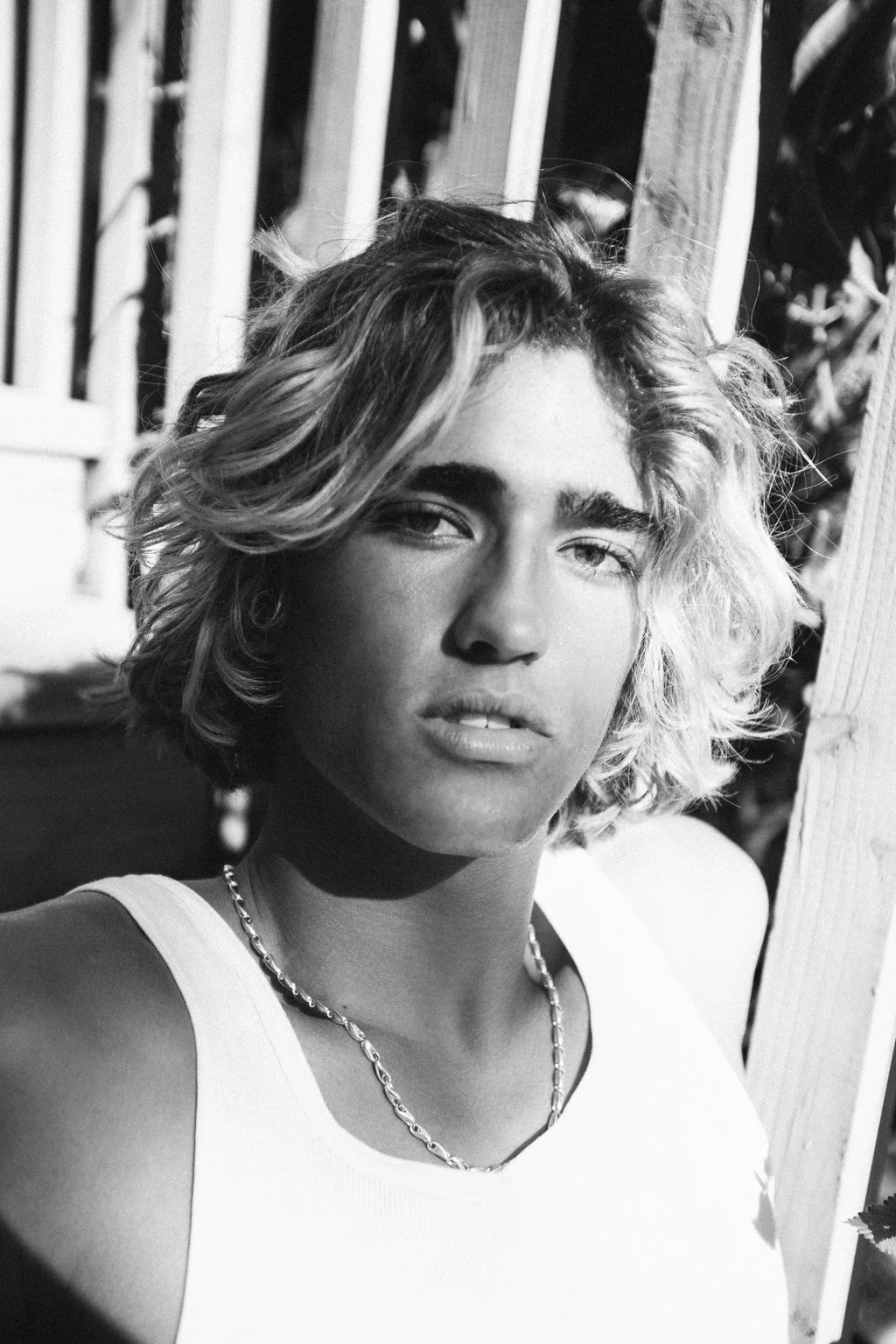 Black-and-white portrait in a white vest and open daylight
